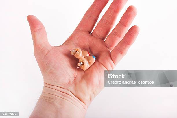 Cic Hearing Aids On A Palm Stock Photo - Download Image Now - Adult, Audiologist, Blue