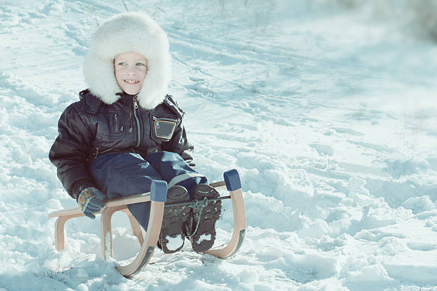 istock Cute young boy laughing as he is sledging downhill in 531141269