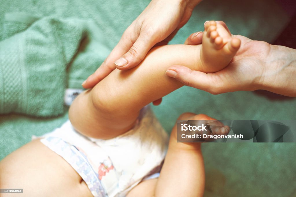 Baby massage Mother massaging her little baby girl, shallow focus 2015 Stock Photo