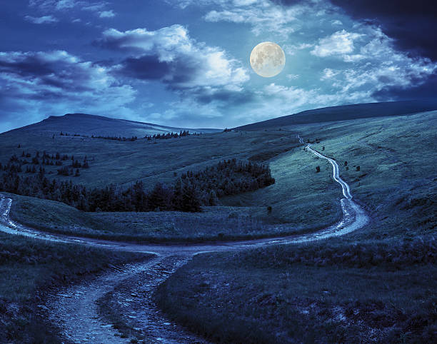 istock cross road on hillside meadow in mountain at night 531151061