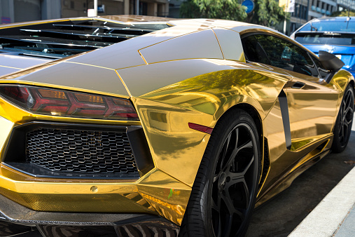 San Francisco, California, USA - September 6, 2014: Vibrant gold painted Lamborghini taken from the back passenger side in the warm climate of San Francisco, California.