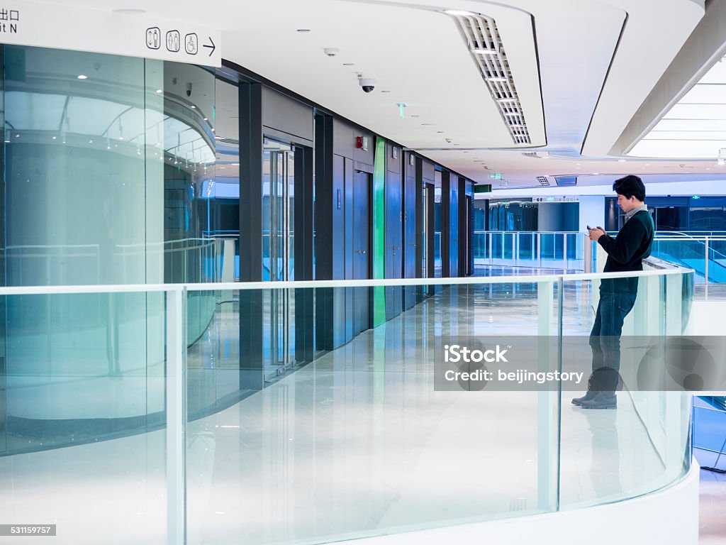 Young man using smartphone Young man using smartphone in architecture 2015 Stock Photo