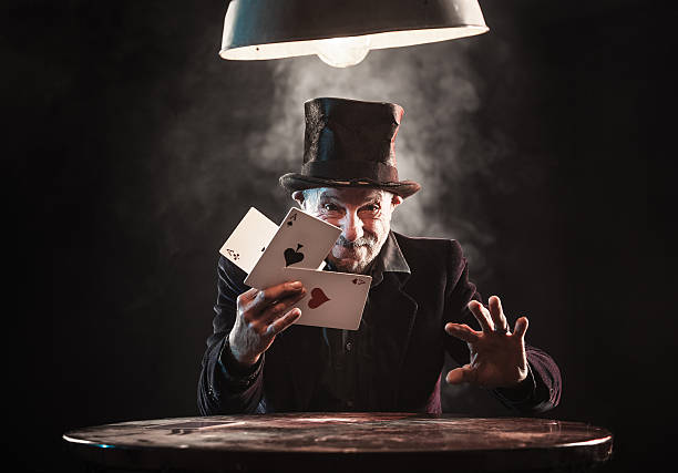 uomo anziano facendo trucchi con le carte da gioco - trucco magico foto e immagini stock