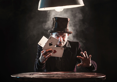 Senior man making trick with playing cards