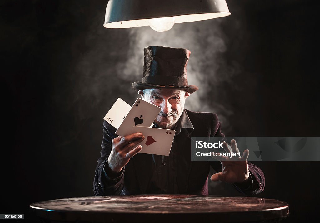 Senior man making trick with playing cards Magician Stock Photo