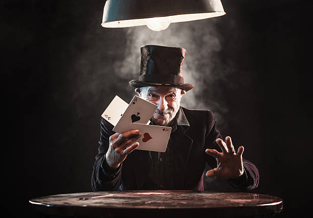 Senior man making trick with playing cards Senior man making trick with playing cards magic trick stock pictures, royalty-free photos & images