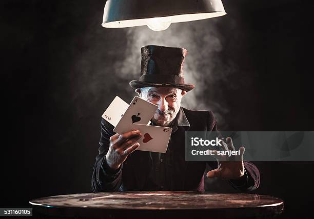 Senior Man Making Trick With Playing Cards Stock Photo - Download Image Now - Magician, Humor, Playing Card