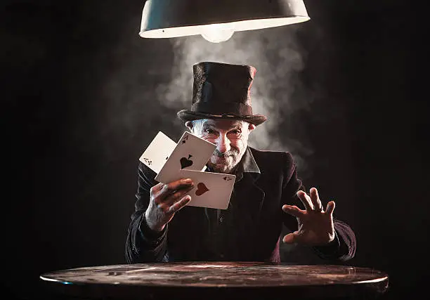 Photo of Senior man making trick with playing cards