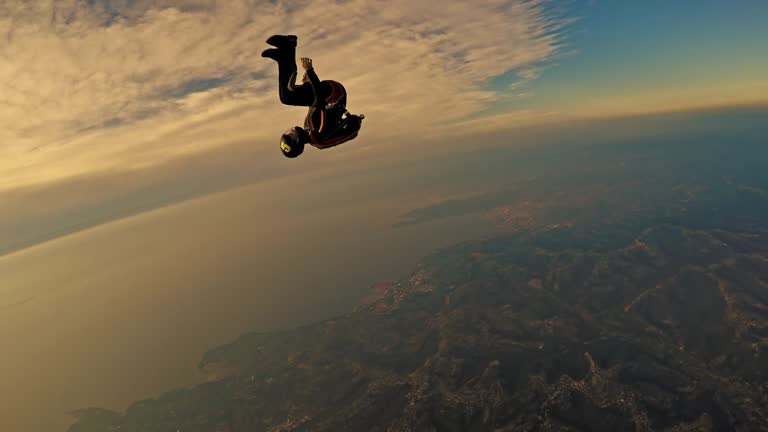 POV Two skydivers enjoying in air over coastline at sunset