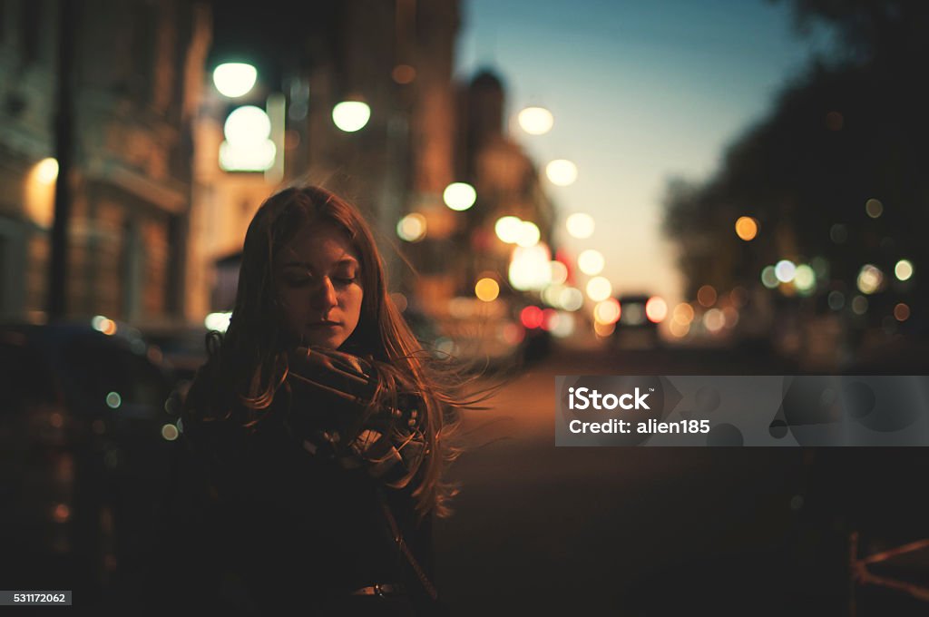 only woman on the night street unhappy woman is walking alone on the night street Night Stock Photo