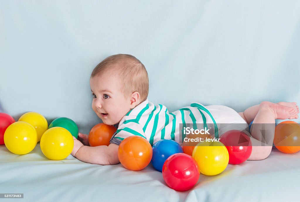 beautiful baby boy Adorable happy baby boy with multicolored balls on blue background 2015 Stock Photo