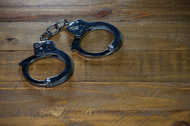 istock Handcuffs on a wooden table 531173892