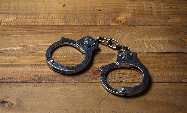 istock Handcuffs on a wooden table 531173972