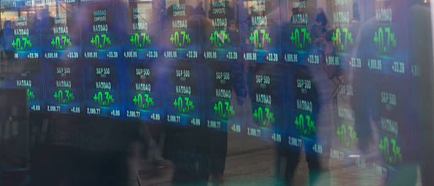 Stock Exchange Display screen showing the days stock market status. NASDAQ, S&P500 and Dow Jones Industrial averages are shown. Hordes of business people's silhouetted reflections are also shown on the display. nikkei index stock pictures, royalty-free photos & images