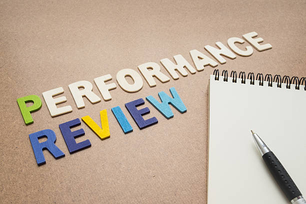 Performance review text with open spiral notebook and pen Performance review text with open spiral notebook and pen on brown background - concept of quality measurement annual event stock pictures, royalty-free photos & images