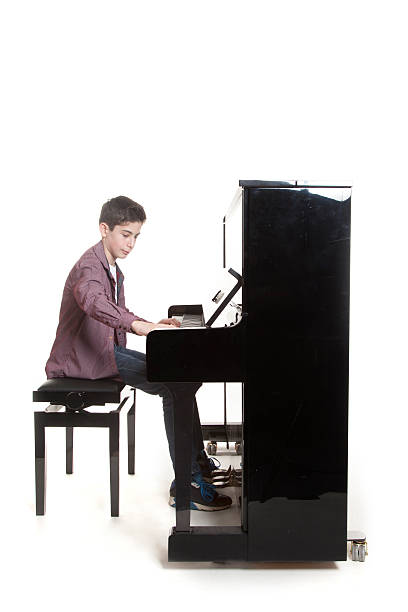 istock teenage boy plays the piano in studio 531175609
