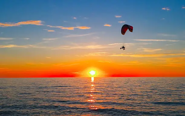 Photo of Sunset at sea and paraglider