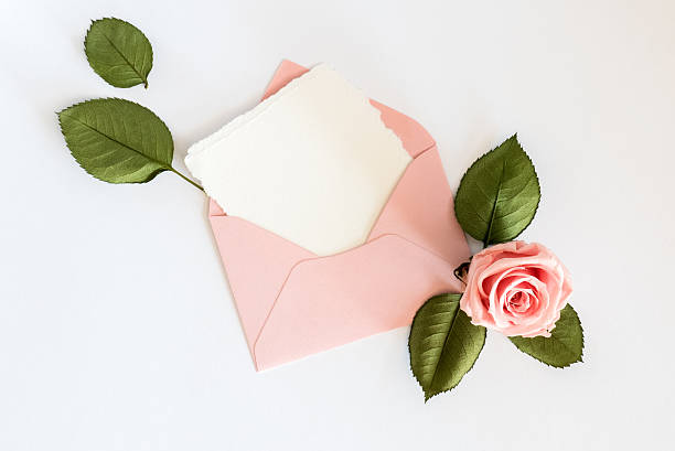 Pink envelop with white card and rose. Flat lay Pink envelop with white card and rose. Flat lay, top view. rose bouquet red table stock pictures, royalty-free photos & images