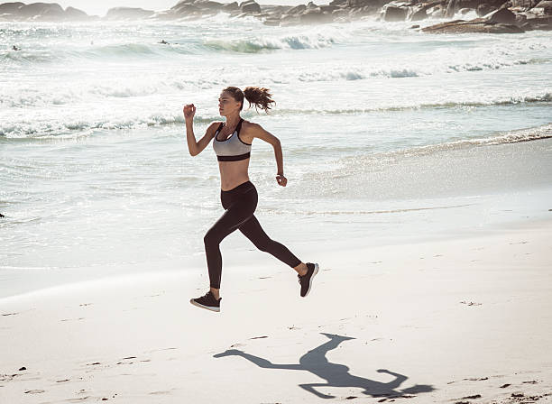 istock fit woman running on the beach 531179736