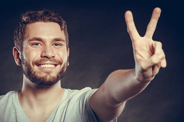 istock Handsome man guy giving peace v sign gesture. 531180954
