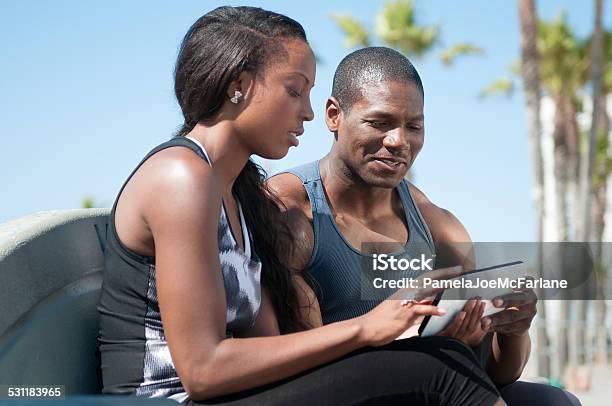 Couple In Athletic Work Out Clothing Reviewing Computer Tablet Stock Photo - Download Image Now