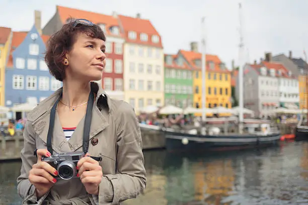 Woman with mirrorless camera on a bridge in Nyhavn, Copenhagen.