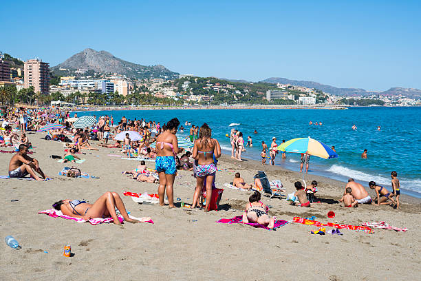 Lloret de mar, Spain - September 13, 2015: The people resting at the sand on beach at seafront in Lloret de mar, Spain on September 13, 2015