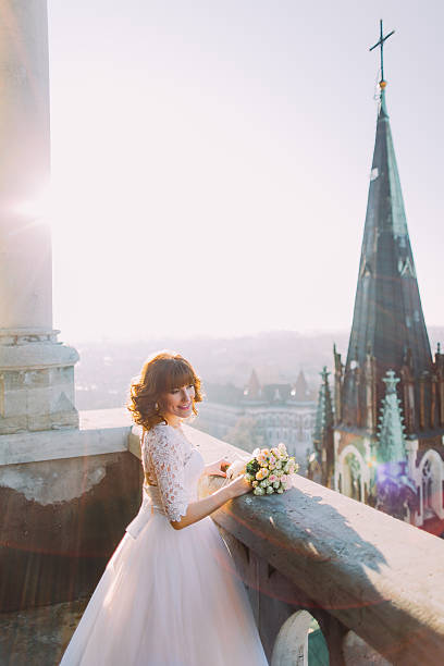 istock Beautiful red-head bride posing with bouquet on old castle 531184772