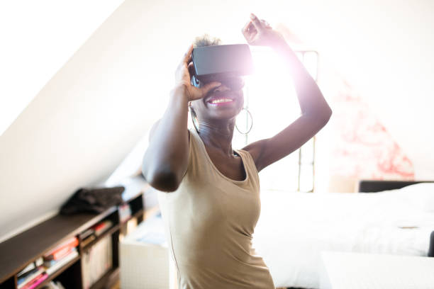 istock afro woman using the VR simulator at home 531184906