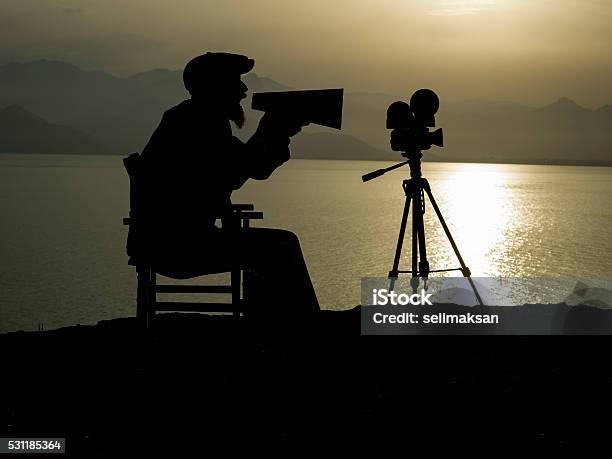 Silhouette Of Adult Man Directing Film In Outdoor Movie Set Stock Photo - Download Image Now