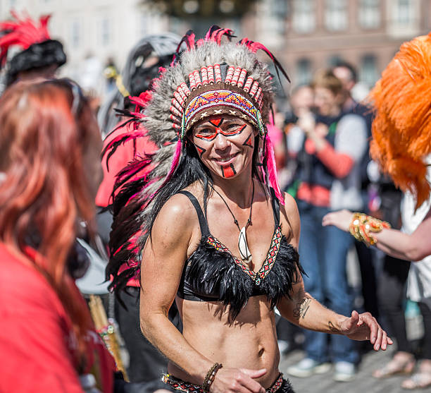 Young woman parading in the Copenhagen Whitsun Carnival, 2016. Copenhagen, Denmark - May 14, 2016: Young woman dressed as a native American parading in the Copenhagen Whitsun Carnival, 2016. whitsun stock pictures, royalty-free photos & images
