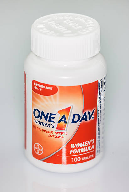 One A Day women's  Multivitamin bottle New York, USA - December 13, 2014: One A Day women's Multivitamin Supplement 100 Tablets bottle. One A Day brand is owned by Bayer AG. bayer schering pharma ag photos stock pictures, royalty-free photos & images