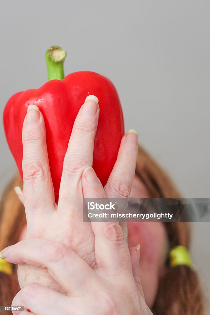 Red pepper and hands covering woman's face 2015 Stock Photo