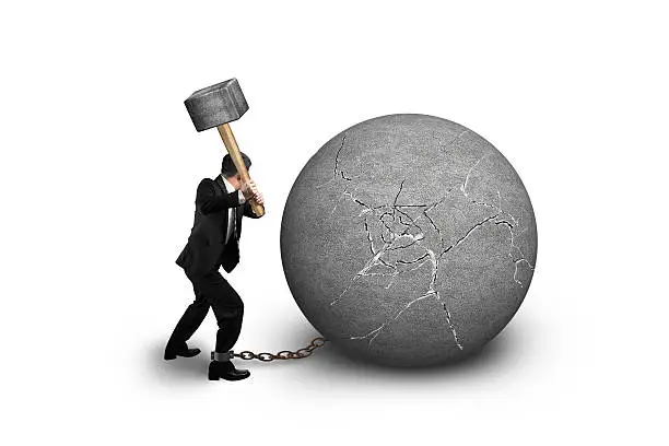 Businessman holding hammer hitting cracked concrete ball isolated on white background