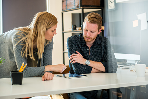 Designers working together on a digital tablet.