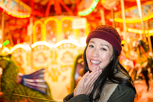 chinese woman happiness in front of a carousel