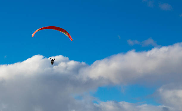 Hanglider Paraglider high in the clouds over the ocean on a summer day glider hang glider hanging sky stock pictures, royalty-free photos & images