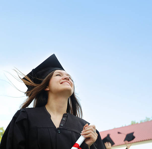 istock Girl in a cap and gown looking up. 531192482
