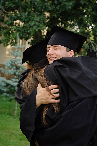 istock The student in a black gown graduate hugging classmate. 531192546