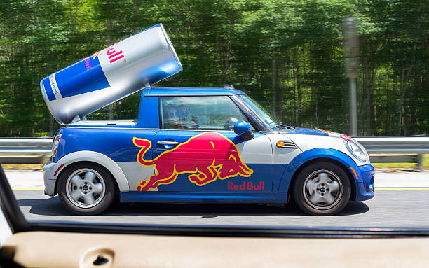 red bull car South Carolina, USA - April 17, 2016: Redbull logo design on Cooper Mini car driven by 2 young women on the I-95 highway in South Carolina. Photographed through the window of the car next to them. red bull mini stock pictures, royalty-free photos & images