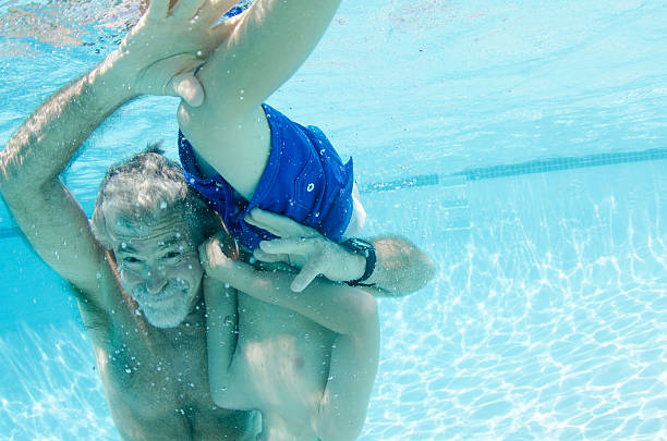 istock Grandpa plays with boy underwater 531194318