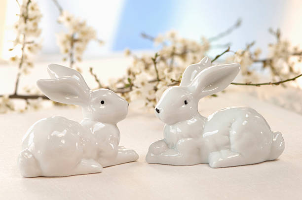 istock Two ceramic bunnies in front of cherry blossoms, close-up 531212859