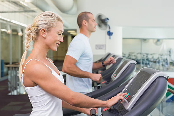 istock Couple running on treadmills at gym 531213949