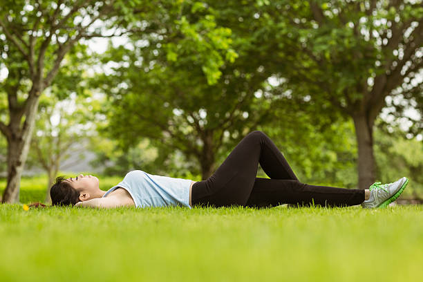 istock Healthy woman lying on grass in park 531214381