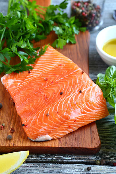 istock Red fish fillet with parsley and basil on cutting board 531224283
