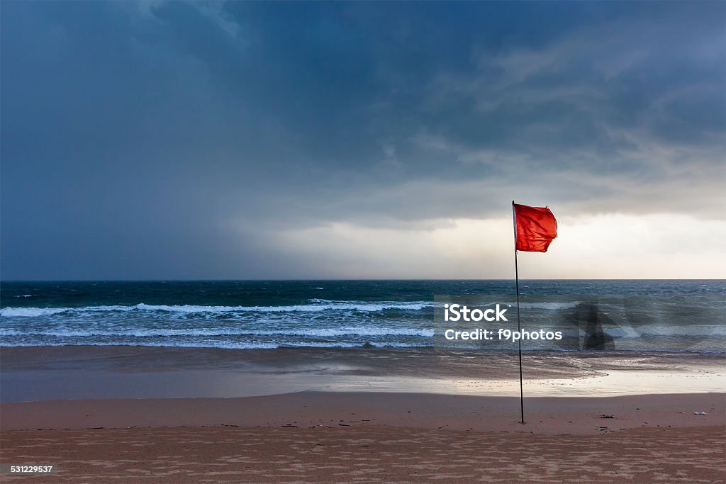 Storm warning flags on beach. Baga, Goa, India Danger concept background - severe storm warning flags on beach. Baga, Goa, India Red Stock Photo