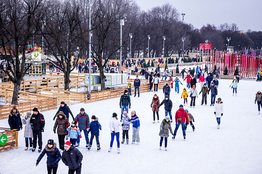 Moscow, Russia - January 03, 2014: People on big skating rink in Gorky Park in Moscow city. Morning time.