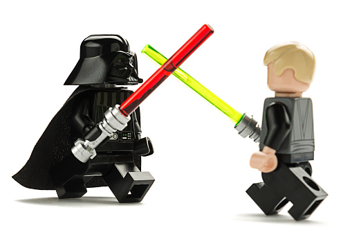 Ankara, Turkey - May 27, 2014: Lego Star Wars minifigure Darth Vader and Luke Skywalker are fighting with sword isolated on white background. 