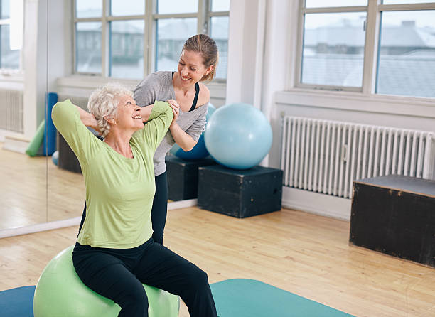 istock Happy senior woman exercising with female instructor 531237347