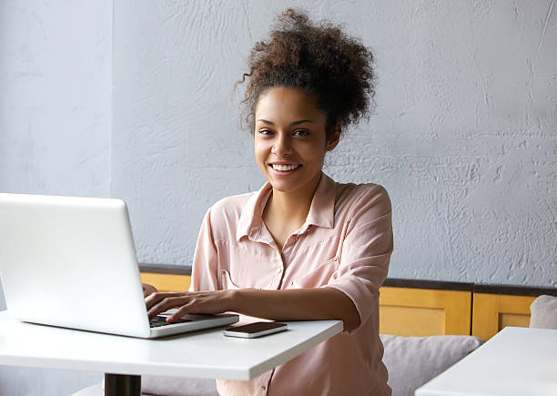 istock Smiling young black woman working on laptop 531240919